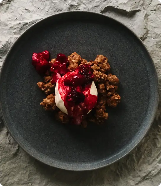 Dessert with berries on black plate