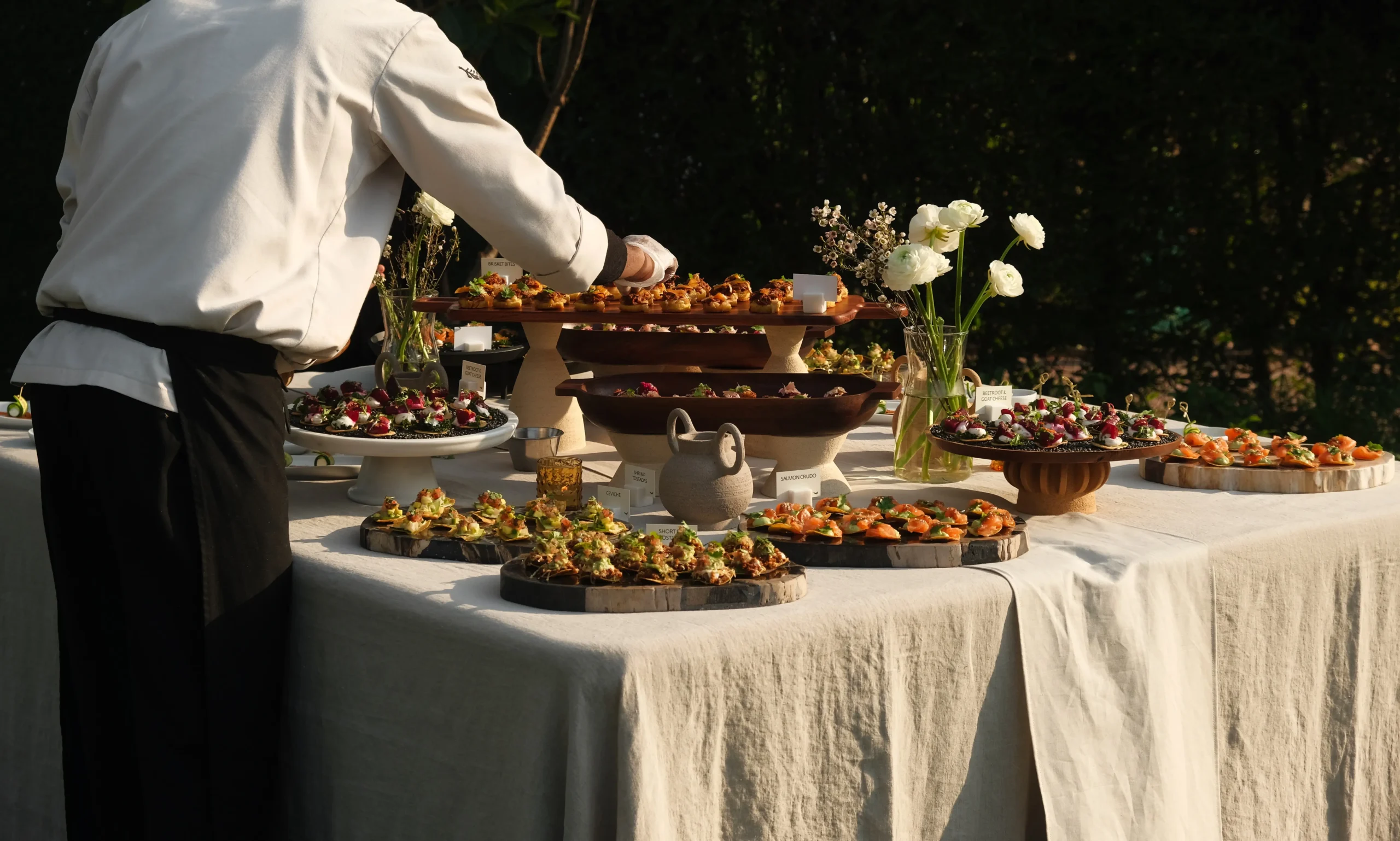 Neo Eatery catering chef arranging appetizers at an outdoor buffet